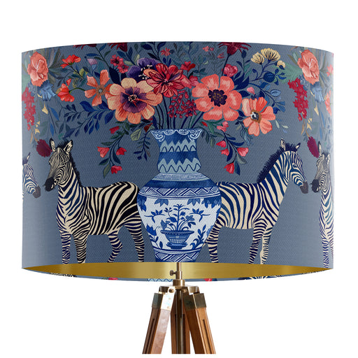 A maximalist design of Zebra's, chinoiserie vases and colourful flowers on a blue backdrop on a classic sized 30x21cm handcrafted fabric lampshade by artist Kelly Stevens-McLaughlan