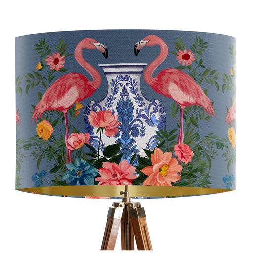 A maximalist design of pink flamingos, chinoiserie vases and colourful flowers on a blue backdrop on a classic sized 30x21cm handcrafted fabric lampshade by artist Kelly Stevens-McLaughlan