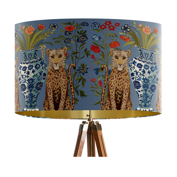 A maximalist design of leopards, chinoiserie vases and colourful flowers on a blue backdrop on a large sized 40x25cm handcrafted fabric lampshade by artist Kelly Stevens-McLaughlan