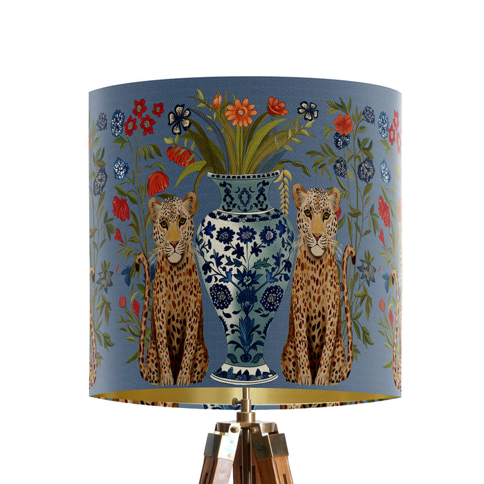 A maximalist design of leopards, chinoiserie vases and colourful flowers on a blue backdrop on a small sized 20x18cm handcrafted fabric lampshade by artist Kelly Stevens-McLaughlan