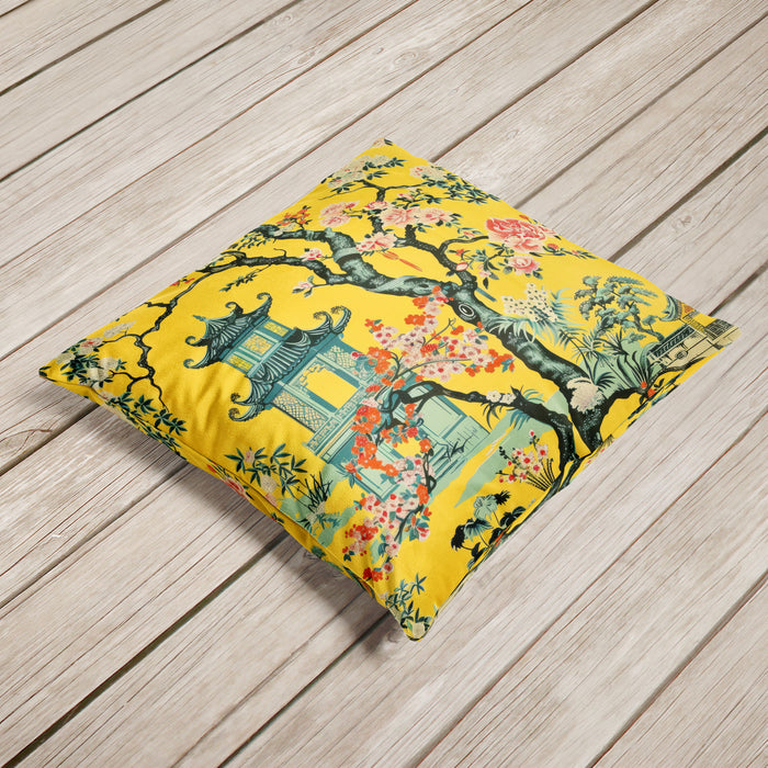 Yellow velvet cushion with pagoda and blooming flowers in a floral landscape.