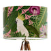 Parrots in white, green & blue along with monkeys sit amoungst green tropical leaves on a pink background on a classic sized 30x21cm handcrafted fabric lampshade by artist Kelly Stevens-McLaughlan