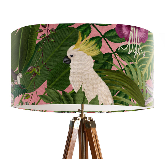 Parrots in white, green & blue along with monkeys sit amoungst green tropical leaves on a pink background on a Extra large sized 45x25cm handcrafted fabric lampshade by artist Kelly Stevens-McLaughlan