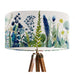 A stylish floral and grass design in harmonious shades of blue and green on a pristine white background on a Extra large sized 45x25cm handcrafted fabric lampshade by artist Kelly Stevens-McLaughlan