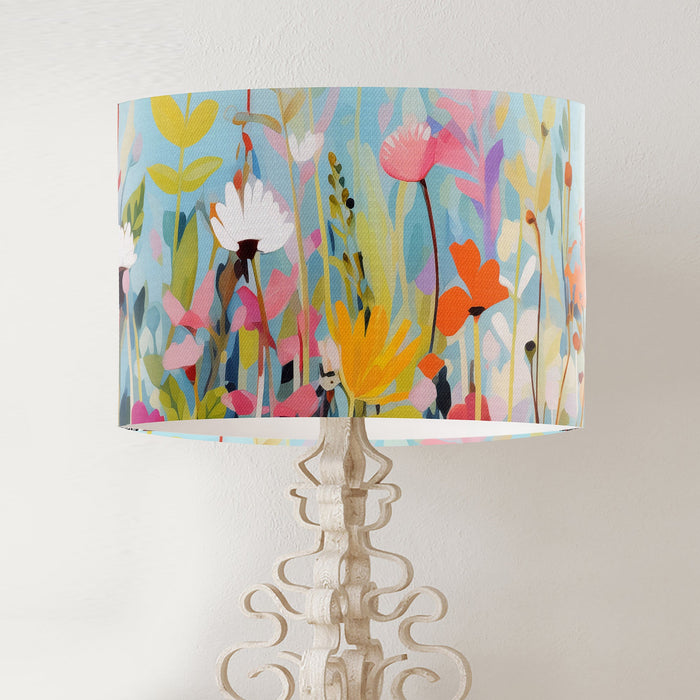 Vinrentia colourful wildflower design against a sky blue backdrop on a classic sized 30x21cm handcrafted fabric lampshade by artist Kelly Stevens-McLaughlan