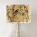 Pink and peach flowers and country garden birds on branches on a soft warm yellow background on a classic sized 30x21cm handcrafted fabric lampshade by artist Kelly Stevens-McLaughlan