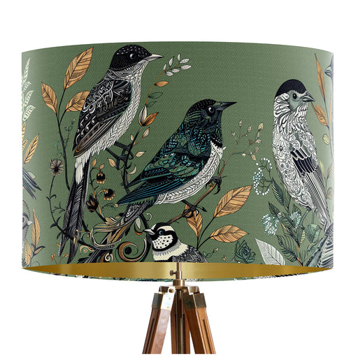 Intricately drawn birds, sit on branches and leaves with a green backdrop on a classic sized 30x21cm handcrafted fabric lampshade by artist Kelly Stevens-McLaughlan