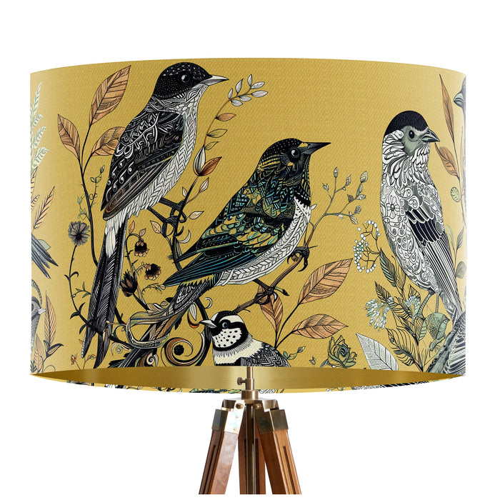 Intricately drawn birds, sit on branches and leaves with a yellow backdrop on a classic sized 30x21cm handcrafted fabric lampshade by artist Kelly Stevens-McLaughlan