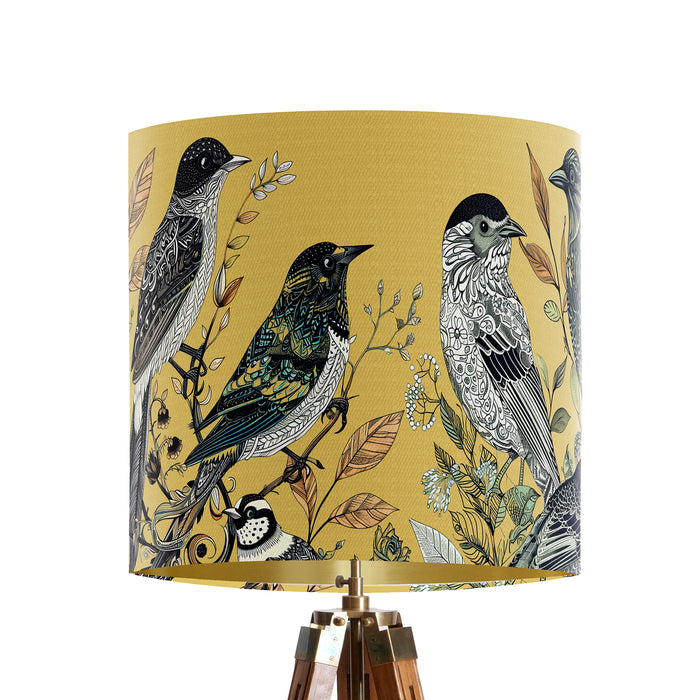 Intricately drawn birds, sit on branches and leaves with a yellow backdrop on a small sized 20x18cm handcrafted fabric lampshade by artist Kelly Stevens-McLaughlan