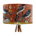 Intricately drawn birds, sit on branches and leaves with a rust orange backdrop on a large sized 40x25cm handcrafted fabric lampshade by artist Kelly Stevens-McLaughlan