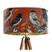 Intricately drawn birds, sit on branches and leaves with a rust orange backdrop on a Extra large sized 45x25cm handcrafted fabric lampshade by artist Kelly Stevens-McLaughlan