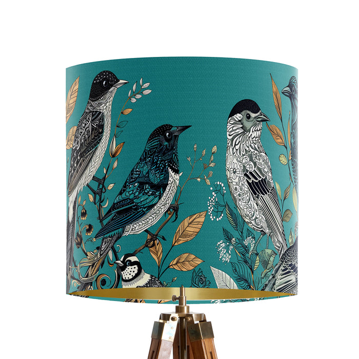 Intricately drawn birds, sit on branches and leaves with a blue backdrop on a small sized 20x18cm handcrafted fabric lampshade by artist Kelly Stevens-McLaughlan