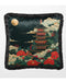 Dark velvet cushion featuring a pagoda illuminated by a golden moon and surrounded by florals with a fringed edge.